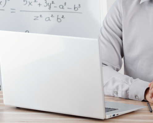 Laptop mit Mathe-Formeln im Hintergrund